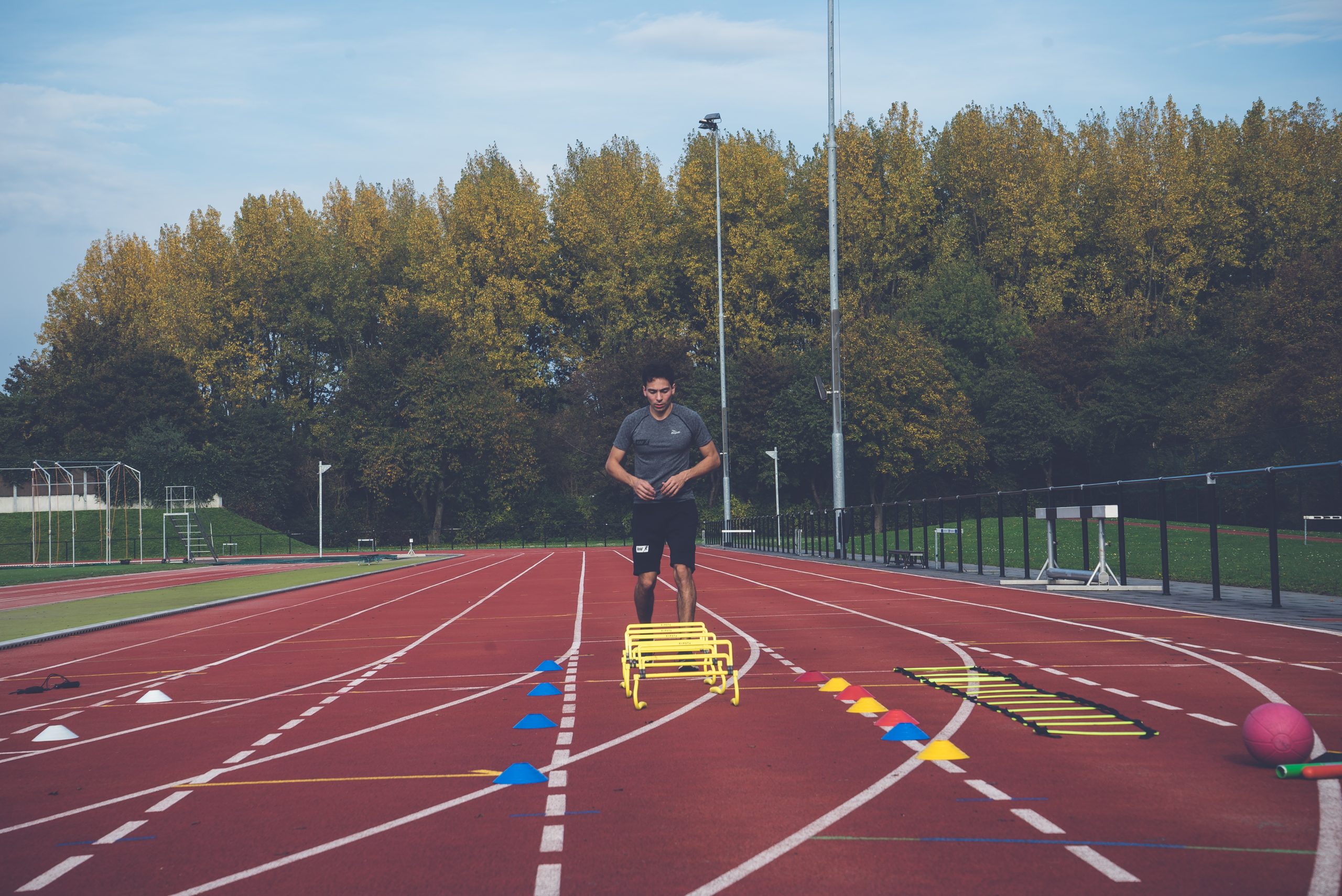 Raf oefent looptechniek met horden op de atletiekbaan